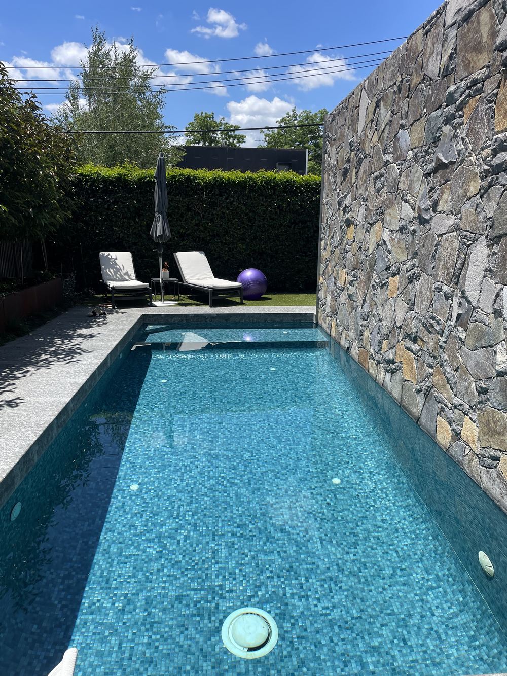 A clean backyard pool with sun loungers, ready to swim, Canberra